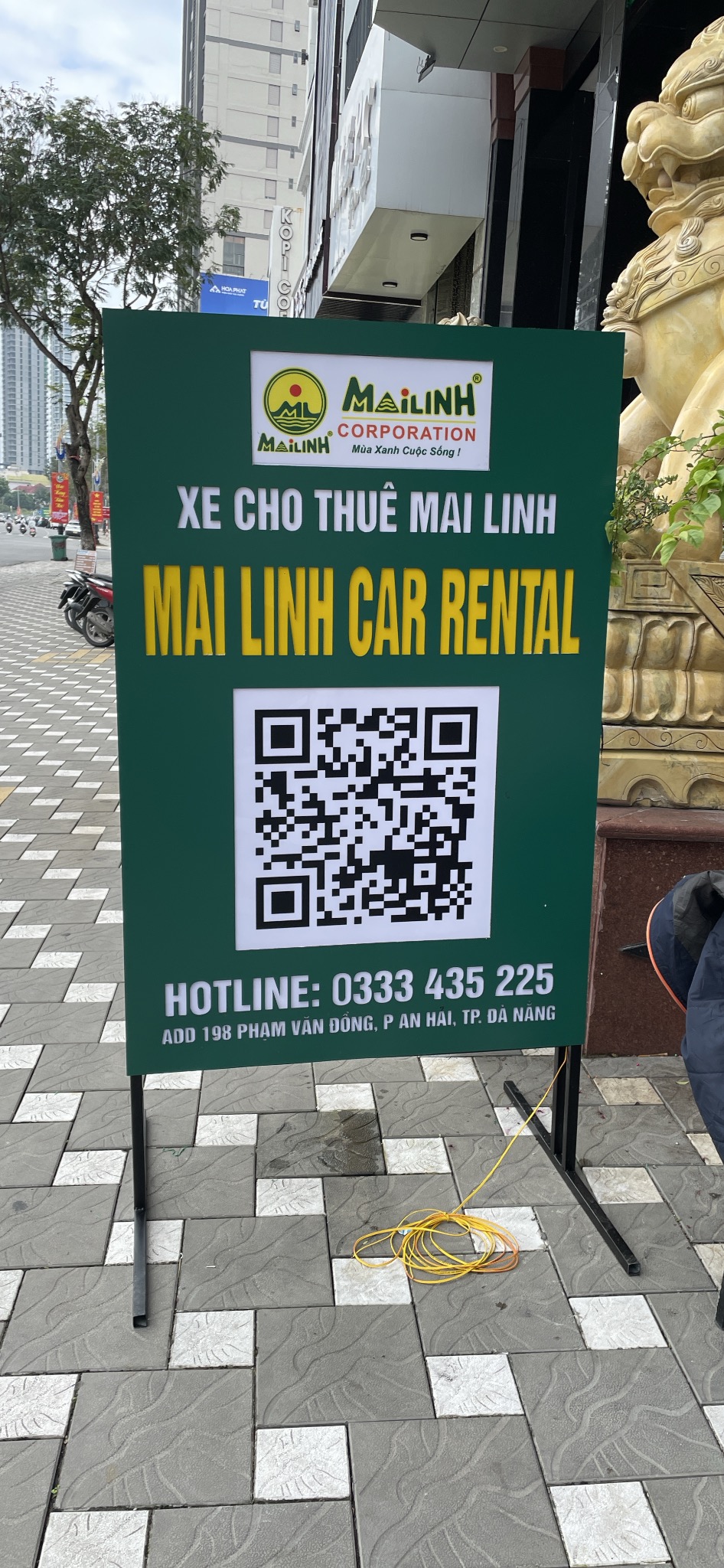 Bảng đứng Mai Linh Car Rental có mã QR đặt trên vỉa hè